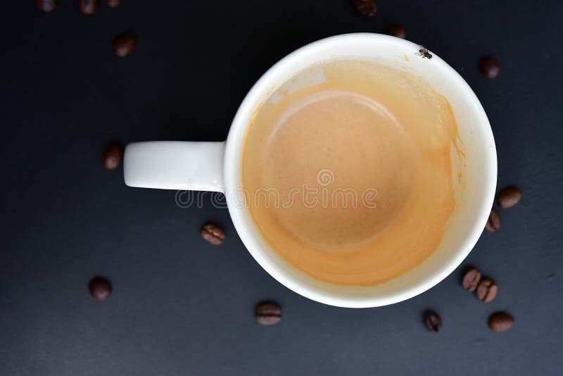 Le chapeau vide de café sur la table en bois foncé contient beaucoup de fèves de café