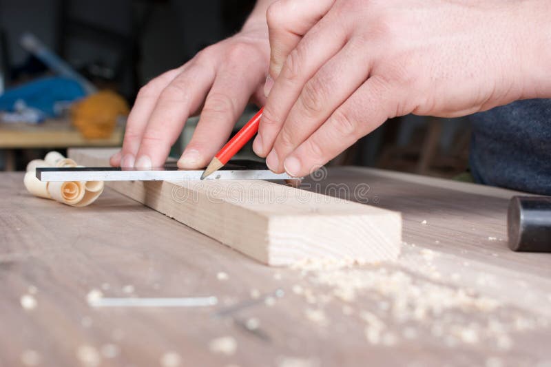 Le charpentier fait l'inscription de la partie en bois dans le crayon rouge image stock