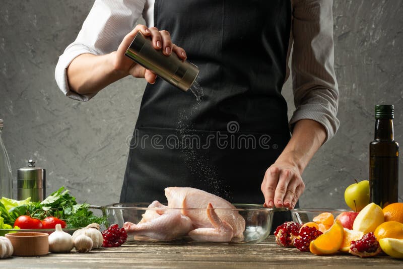 Le chef arrose le sel et le poulet avec le fruit pour faire pendant cuire au four des vacances, Noël, nouvelle année, jour d'avan photos stock Le chef arrose le sel et le poulet avec le fruit pour faire pendant cuire au four des vacances, Noël, nouvelle année, jour d'avan photos stock