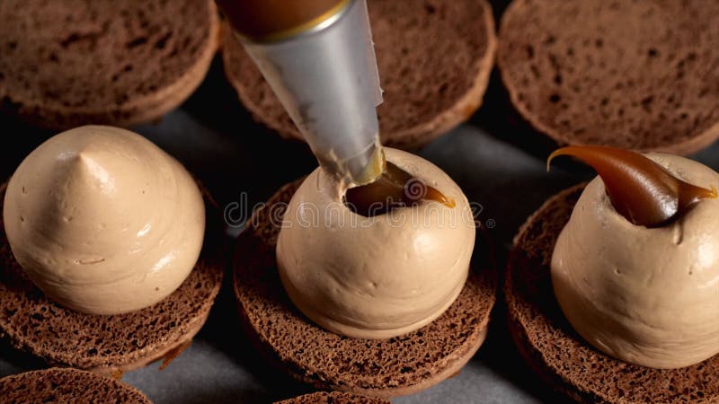 Le chef fait le gros plan de caramel macarons. banque de vidéos