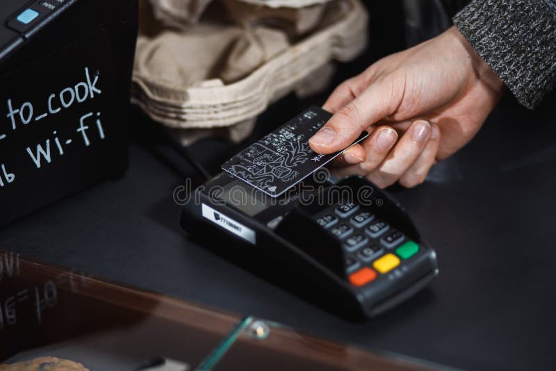 Le client paye avec la carte de crédit sans contact dans la boutique photo libre de droits