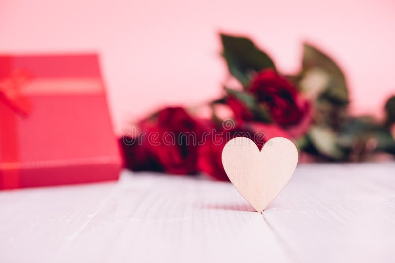 Le coeur en bois sur en bois blanc ont les roses de fleur et le fond rouges de bo?te-cadeau images libres de droits Le coeur en bois sur en bois blanc ont les roses de fleur et le fond rouges de bo?te-cadeau images libres de droits