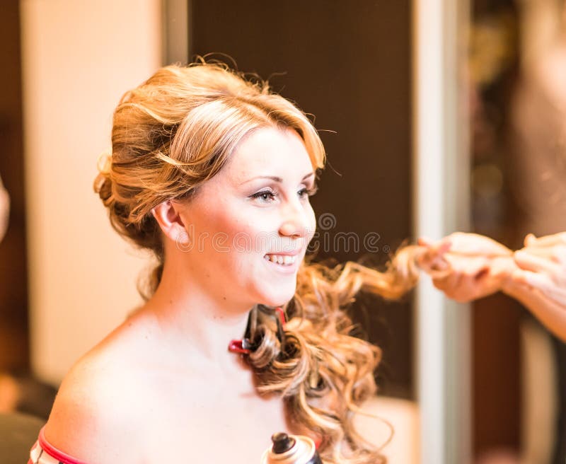 Le coiffeur fait une coiffure à la jeune mariée images libres de droits Le coiffeur fait une coiffure à la jeune mariée images libres de droits