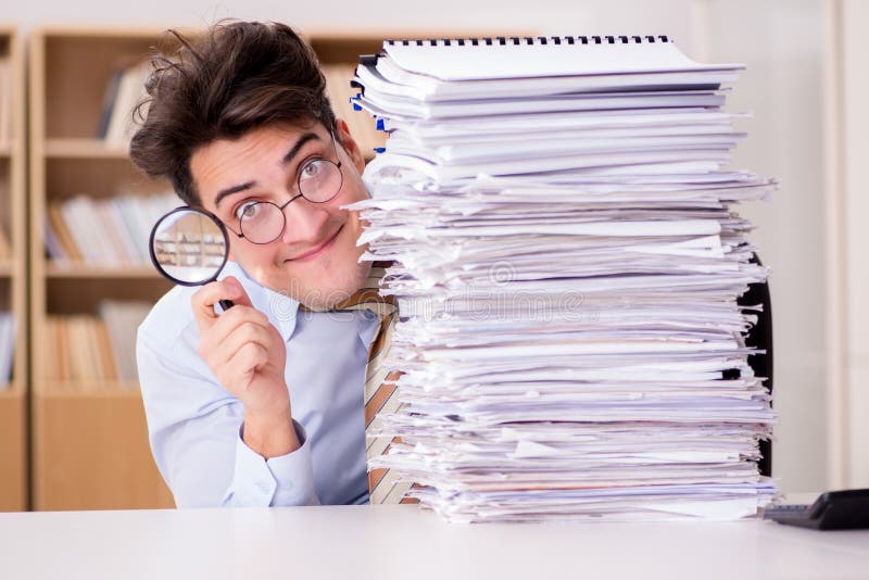 Le commissaire aux comptes drôle vérifiant des rapports avec la loupe image stock