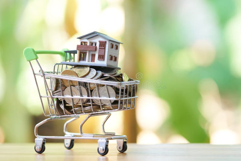 Le concept d'argent d'économie du rassemblement invente l'argent thaïlandais dans un modèle de caddie et de maison sur le fond de photo stock Le concept d'argent d'économie du rassemblement invente l'argent thaïlandais dans un modèle de caddie et de maison sur le fond de photo stock