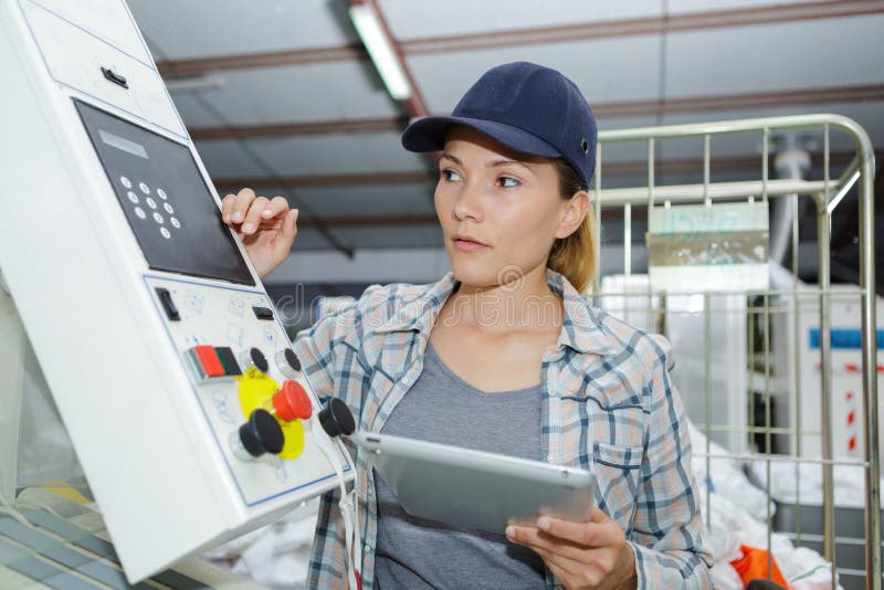 Le contrôle de femme boutonne l'opérateur d'usine de machine photos stock