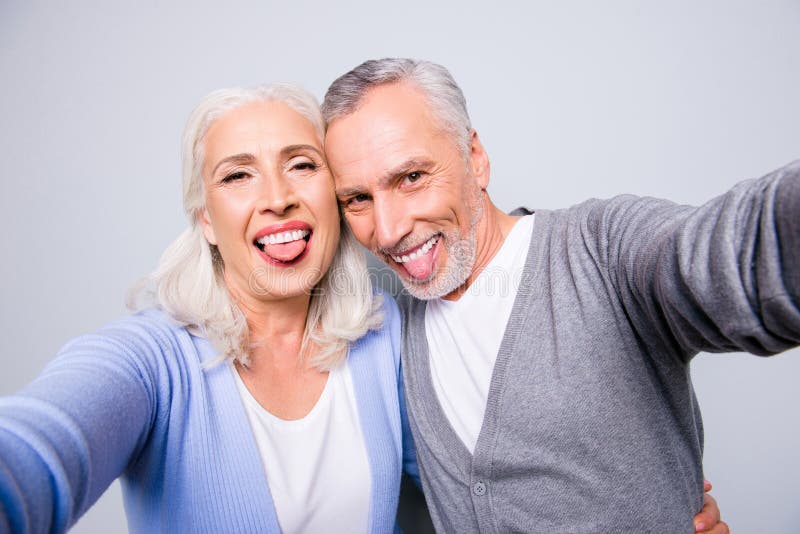 Le coppie anziane divertenti funky pazze stanno prendendo il selfie facendo uso di smartph fotografia stock libera da diritti Le coppie anziane divertenti funky pazze stanno prendendo il selfie facendo uso di smartph fotografia stock libera da diritti