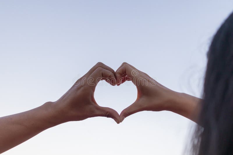 Le coppie di valentina usano le mani per fare simboli di cuore per simboleggiare l'amicizia e l'amore verso l'amante e fotografia stock