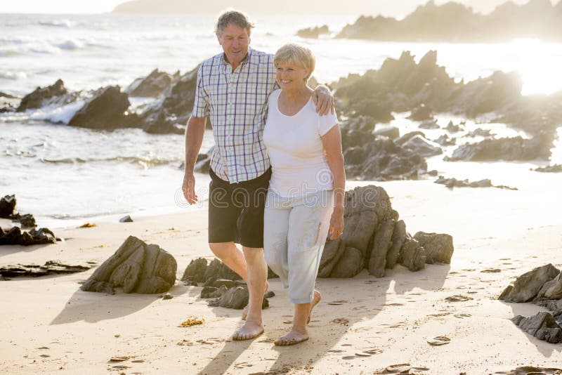 Le coppie mature senior adorabili sul loro 60s o 70s si sono ritirate la camminata felice e rilassata sulla riva di mare della sp fotografie stock Le coppie mature senior adorabili sul loro 60s o 70s si sono ritirate la camminata felice e rilassata sulla riva di mare della sp fotografie stock