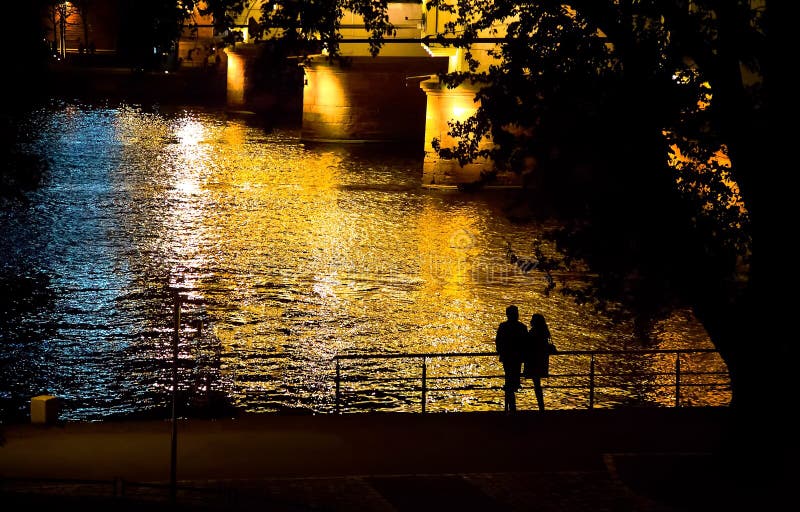 Le coppie profilano vicino al fiume alla notte fotografia stock libera da diritti Le coppie profilano vicino al fiume alla notte fotografia stock libera da diritti