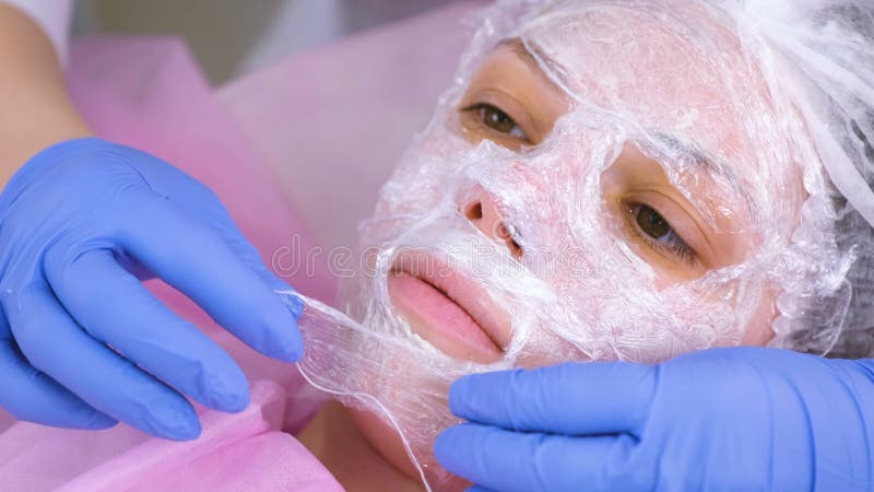 https://thumbs.dreamstime.com/b/le-cosm%C3%A9tologue-met-un-film-plastique-sur-visage-de-la-femme-masque-hydratant-158515732.jpg