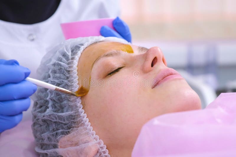 Le Cosmetologist met l'épluchage chimique du visage de la femme avec la brosse Nettoyage de la peau de visage et éclairage de la photos libres de droits Le Cosmetologist met l'épluchage chimique du visage de la femme avec la brosse Nettoyage de la peau de visage et éclairage de la photos libres de droits