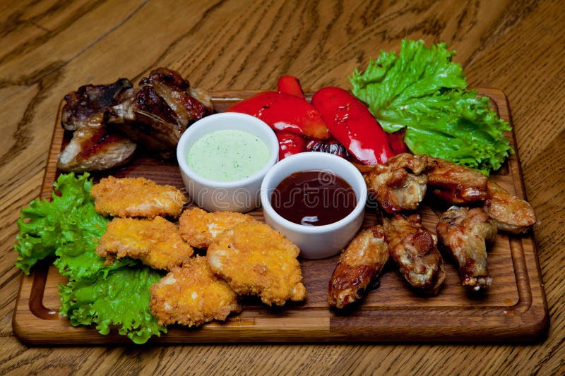 Le costole di carne di maiale con miele sauce, ali di pollo piccanti, peperoni arrostiti fotografia stock libera da diritti Le costole di carne di maiale con miele sauce, ali di pollo piccanti, peperoni arrostiti fotografia stock libera da diritti
