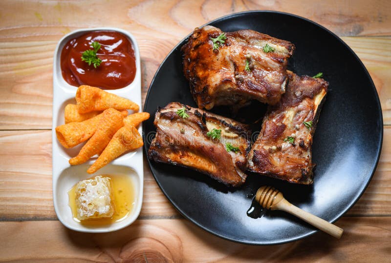 Le costole di carne di maiale del Bbq grigliate con la salsa del miele e le spezie dolci delle erbe sono servito sulla tavola - c fotografia stock libera da diritti Le costole di carne di maiale del Bbq grigliate con la salsa del miele e le spezie dolci delle erbe sono servito sulla tavola - c fotografia stock libera da diritti