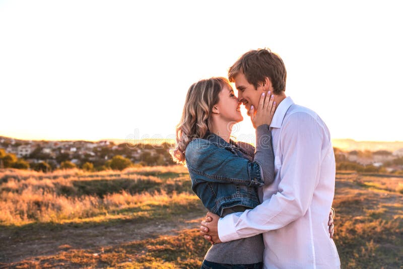 Le couple aimant est à propos de baiser au coucher du soleil. image libre de droits
