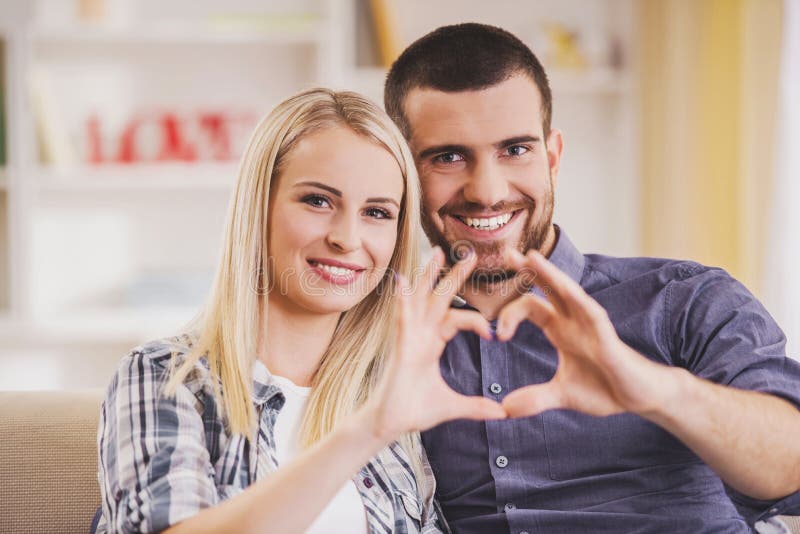 Le couple dans l'amour fait le symbole du coeur avec des mains image stock Le couple dans l'amour fait le symbole du coeur avec des mains image stock