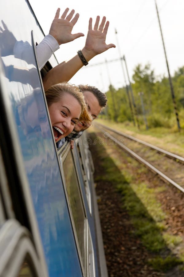 Couple waving with heads out train window enthusiastic women man. Couple waving with heads out train window enthusiastic women man