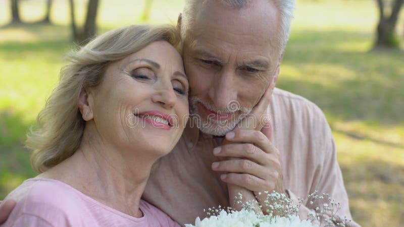 Le couple supérieur la première date, homme donne des fleurs à la femme, amour mûr, roman