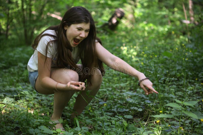 Le cri de fille d'adolescent voient le serpent dans l'herbe images libres de droits Le cri de fille d'adolescent voient le serpent dans l'herbe images libres de droits