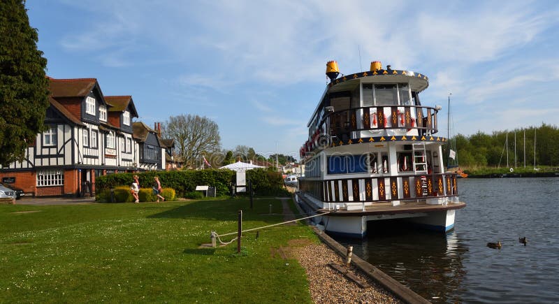 Le croiseur de bateau a amarré sur la rivière Bure chez Horning à côté de l'auberge de cygne photographie stock Le croiseur de bateau a amarré sur la rivière Bure chez Horning à côté de l'auberge de cygne photographie stock