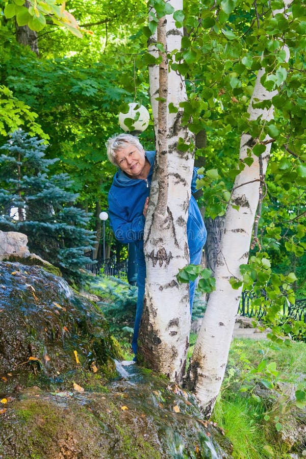 Le den höga kvinnan bak björken arkivbild Le den höga kvinnan bak björken arkivbild