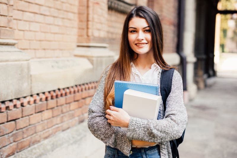 Le den kvinnliga studenten i svart glasögon med mappar och påsen i baksidan arkivfoto Le den kvinnliga studenten i svart glasögon med mappar och påsen i baksidan arkivfoto
