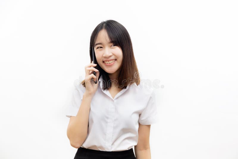 Le den lyckliga och gladlynta asiatiska kvinnliga formella klänningen som rymmer en smart mobiltelefon som gör en påringning isol arkivbilder Le den lyckliga och gladlynta asiatiska kvinnliga formella klänningen som rymmer en smart mobiltelefon som gör en påringning isol arkivbilder