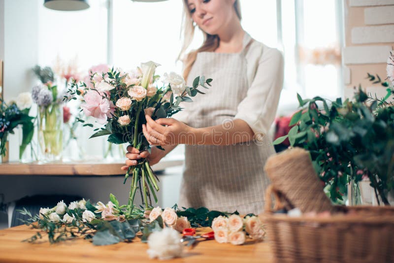 Le den älskvärda blomsterhandlaren för ung kvinna som ordnar växter i blomsterhandel