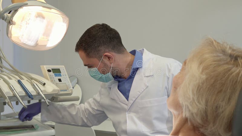 Le dentiste commence le contrôle du patient féminin banque de vidéos
