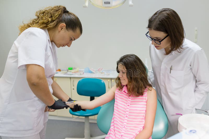 Le dentiste fait une injection dans la main, vérifie la réaction du corps aux préparations anesthésiques photos libres de droits Le dentiste fait une injection dans la main, vérifie la réaction du corps aux préparations anesthésiques photos libres de droits