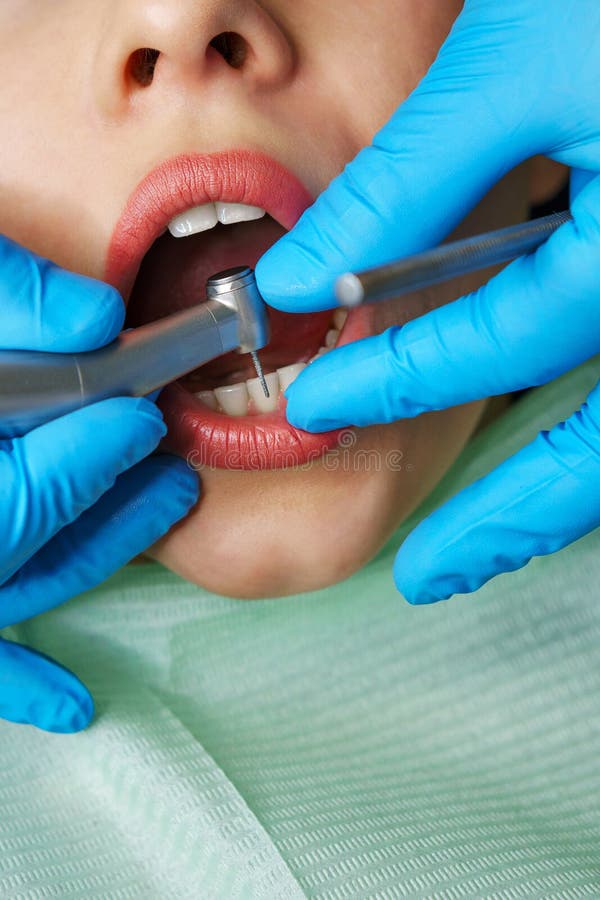 Le dentiste traite les dents de la fille photo libre de droits Le dentiste traite les dents de la fille photo libre de droits