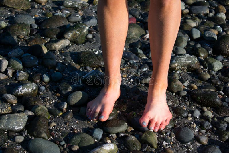Le dita del piede della ragazza sulla spiaggia fotografia stock Le dita del piede della ragazza sulla spiaggia fotografia stock