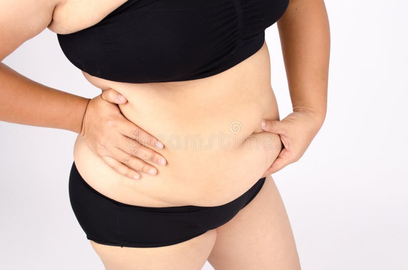 Le dita della donna che misurano il suo grasso della pancia immagine stock libera da diritti Le dita della donna che misurano il suo grasso della pancia immagine stock libera da diritti