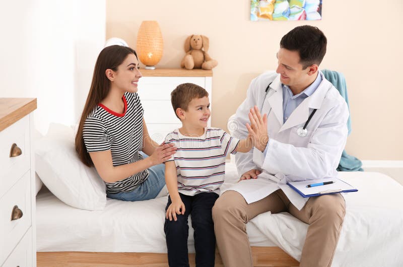 Le docteur des enfants rendant visite au petit patient photographie stock Le docteur des enfants rendant visite au petit patient photographie stock