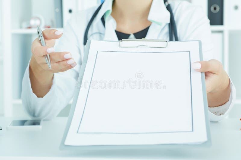 Le docteur féminin méconnaissable remet tient le presse-papiers avec la page du papier blanche photos libres de droits Le docteur féminin méconnaissable remet tient le presse-papiers avec la page du papier blanche photos libres de droits