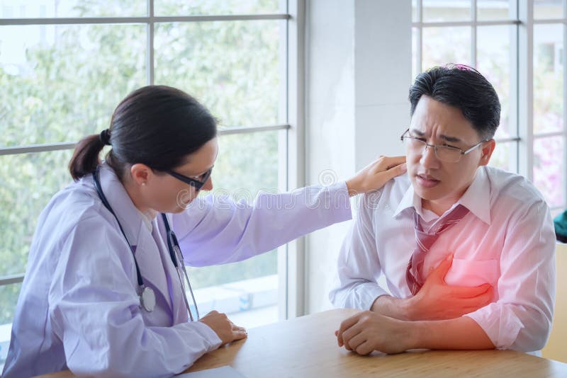 Le docteur féminin supérieur consulte le jeune patient s'asseyant au docteur de image stock Le docteur féminin supérieur consulte le jeune patient s'asseyant au docteur de image stock