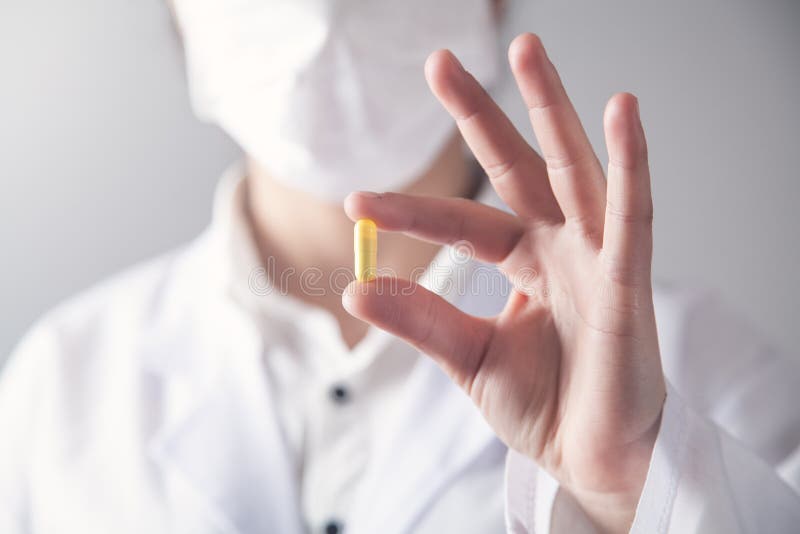 Le docteur tient la pilule jaune dans sa main Concept M? DICAL photo libre de droits