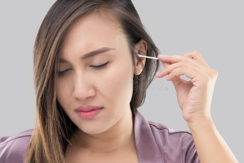 Le donne asiatiche in abiti puliscono le sue orecchie fotografie stock libere da diritti Le donne asiatiche in abiti puliscono le sue orecchie fotografie stock libere da diritti