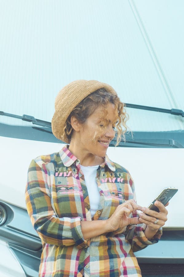 Le donne guidatrici apprezzano l'area parcheggio rv del camper usando l'app telefonica per pianificare la prossima destinazione de immagini stock