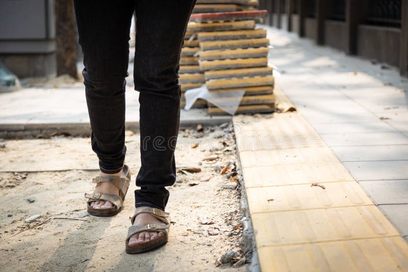 Le donne pedoni camminano su una passerella pedonale in costruzione e hanno impilato pietre o ristrutturato, danneggiate