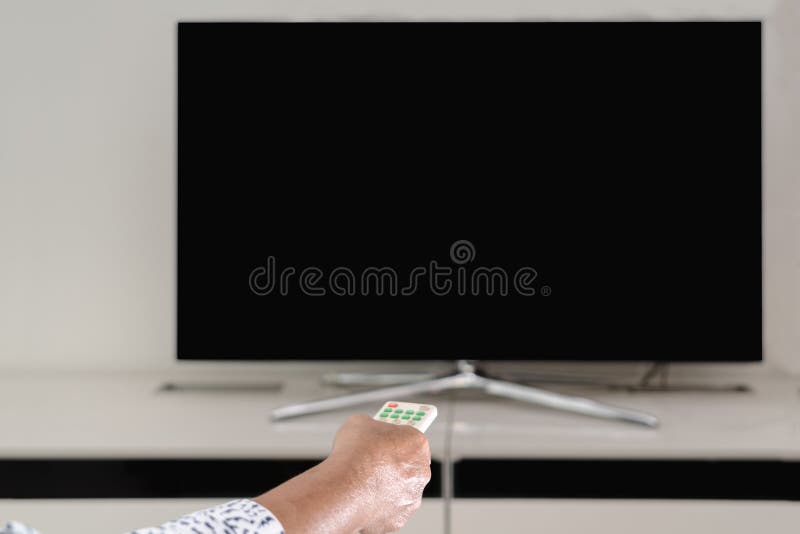 Le donne senior passano il telecomando della scatola della TV che guarda, esposizione in bianco della tenuta fotografie stock Le donne senior passano il telecomando della scatola della TV che guarda, esposizione in bianco della tenuta fotografie stock