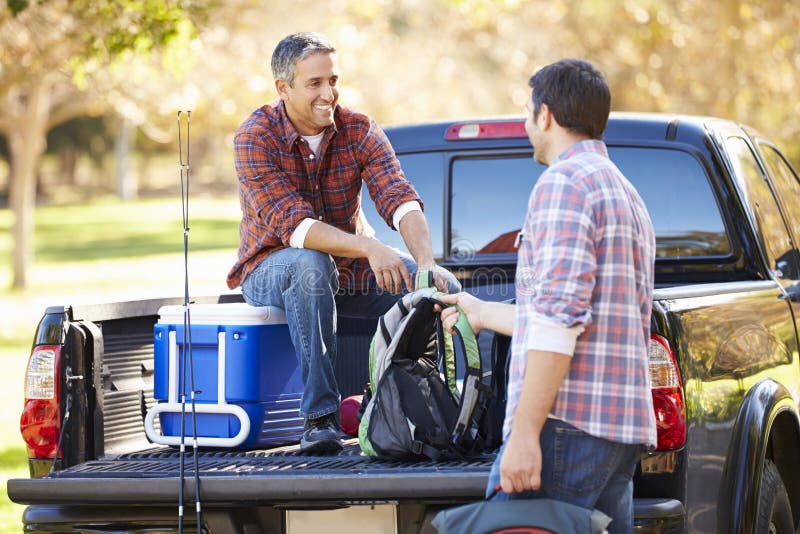 Le déballage de deux hommes prennent le camion des vacances de camping image libre de droits Le déballage de deux hommes prennent le camion des vacances de camping image libre de droits
