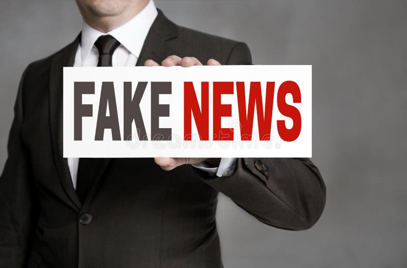 Le faux label d'actualités est tenu par l'homme d'affaires photos stock Le faux label d'actualités est tenu par l'homme d'affaires photos stock