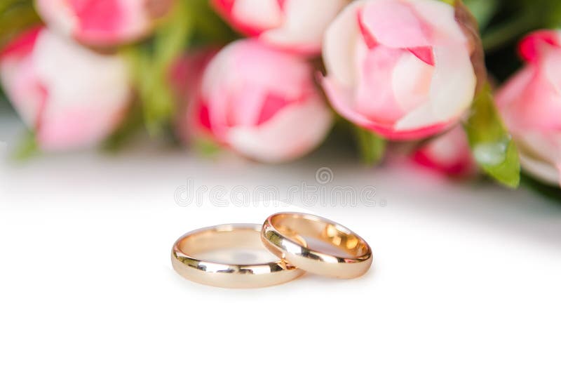 Le fedi nuziali ed i fiori isolati su fondo bianco fotografie stock libere da diritti Le fedi nuziali ed i fiori isolati su fondo bianco fotografie stock libere da diritti