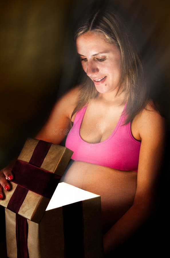 Le Femme Enceinte Ouvre Le Cadeau De Noël De Cadre De Cadeau Image
