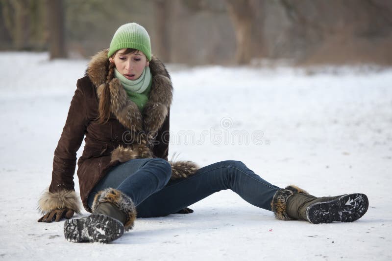 Woman slips and falls down on snowy road. Woman slips and falls down on snowy road