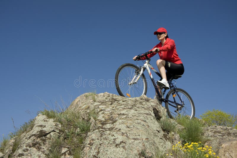 Le femme sur la bicyclette de montagne photo stock Le femme sur la bicyclette de montagne photo stock