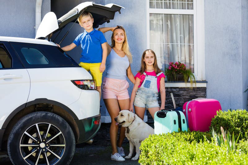 Le feste pronte della casa del bagaglio del bambino della ragazza del cane di Labrador delle valigie di vacanza di famiglia del s fotografia stock Le feste pronte della casa del bagaglio del bambino della ragazza del cane di Labrador delle valigie di vacanza di famiglia del s fotografia stock