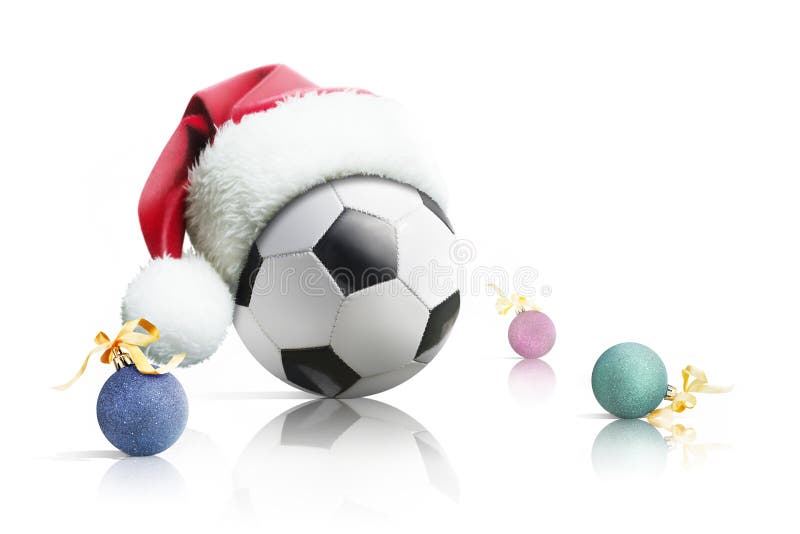 Le football de Noël Le ballon de football dans Noël de chapeau de Santa joue sur un fond blanc D'isolement images libres de droits Le football de Noël Le ballon de football dans Noël de chapeau de Santa joue sur un fond blanc D'isolement images libres de droits