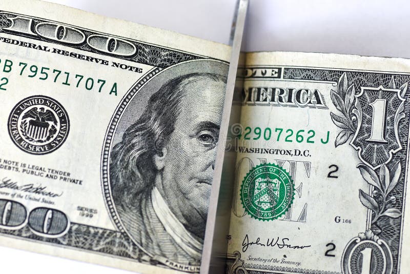 Le forbici di concetto hanno tagliato i cento dollari ed una banconota in dollari su fondo bianco fotografie stock Le forbici di concetto hanno tagliato i cento dollari ed una banconota in dollari su fondo bianco fotografie stock